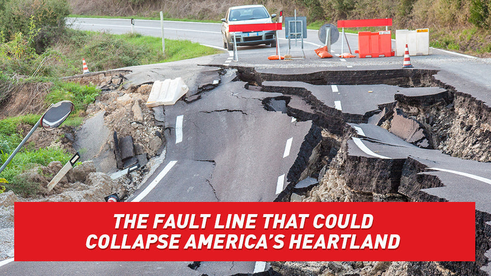 An asphalt road cracked and sunk down the middle.