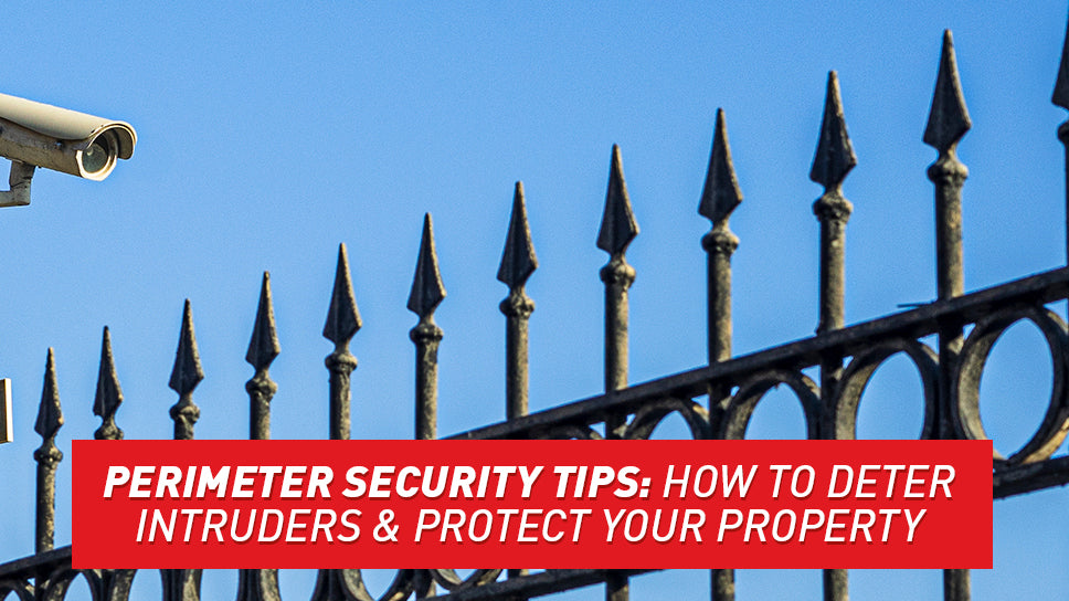 A tall spiked fence with an even taller security camera hovering over it.