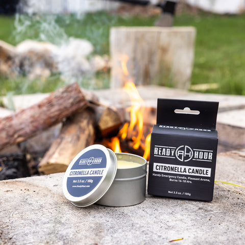Image of citronella candle by ready hour and packaging sitting next to a campfire