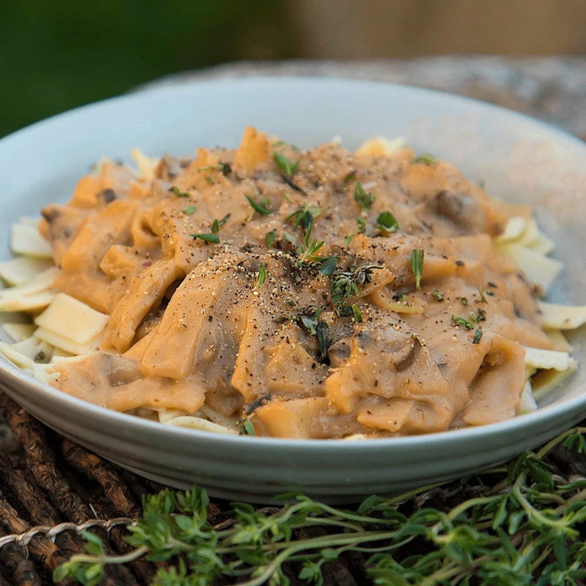 Bowl of Creamy Stroganoff with black pepper and thyme as garnish