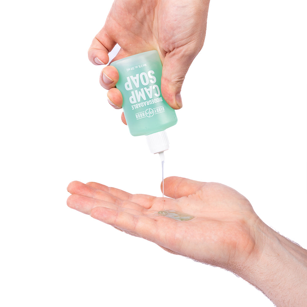 Hand pouring camp soap against white background