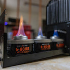 InstaFire 6-Hour Canned Heat cans with flames in a workshop setting