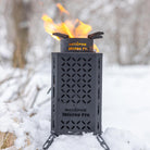 The Inferno Pro on a pile of snow, lit and ready to cook.