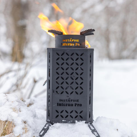 Image of The Inferno Pro on a pile of snow, lit and ready to cook.