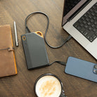Grid Doctor 65W Power Bank on a desk charging a laptop and a phone