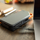 Grid Doctor 65W Power Bank on a desk charging a laptop