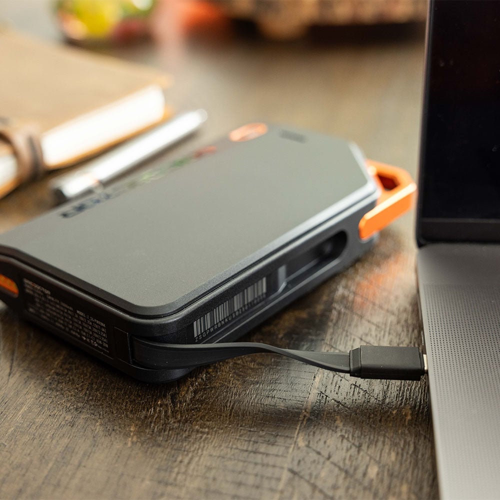 Grid Doctor 65W Power Bank on a desk charging a laptop