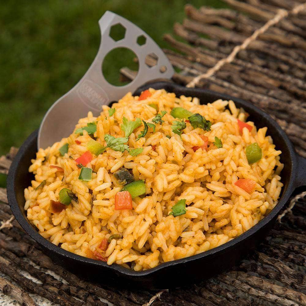 Our Southwest Savory Rice in a cast-iron skillet with a camping utensil to the side. Pair with our Freeze-Dried Chicken for a full meal! Perfect for your emergency food supply.
