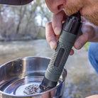 Man using the Survival Straw Personal Water Filter to drink from a cup