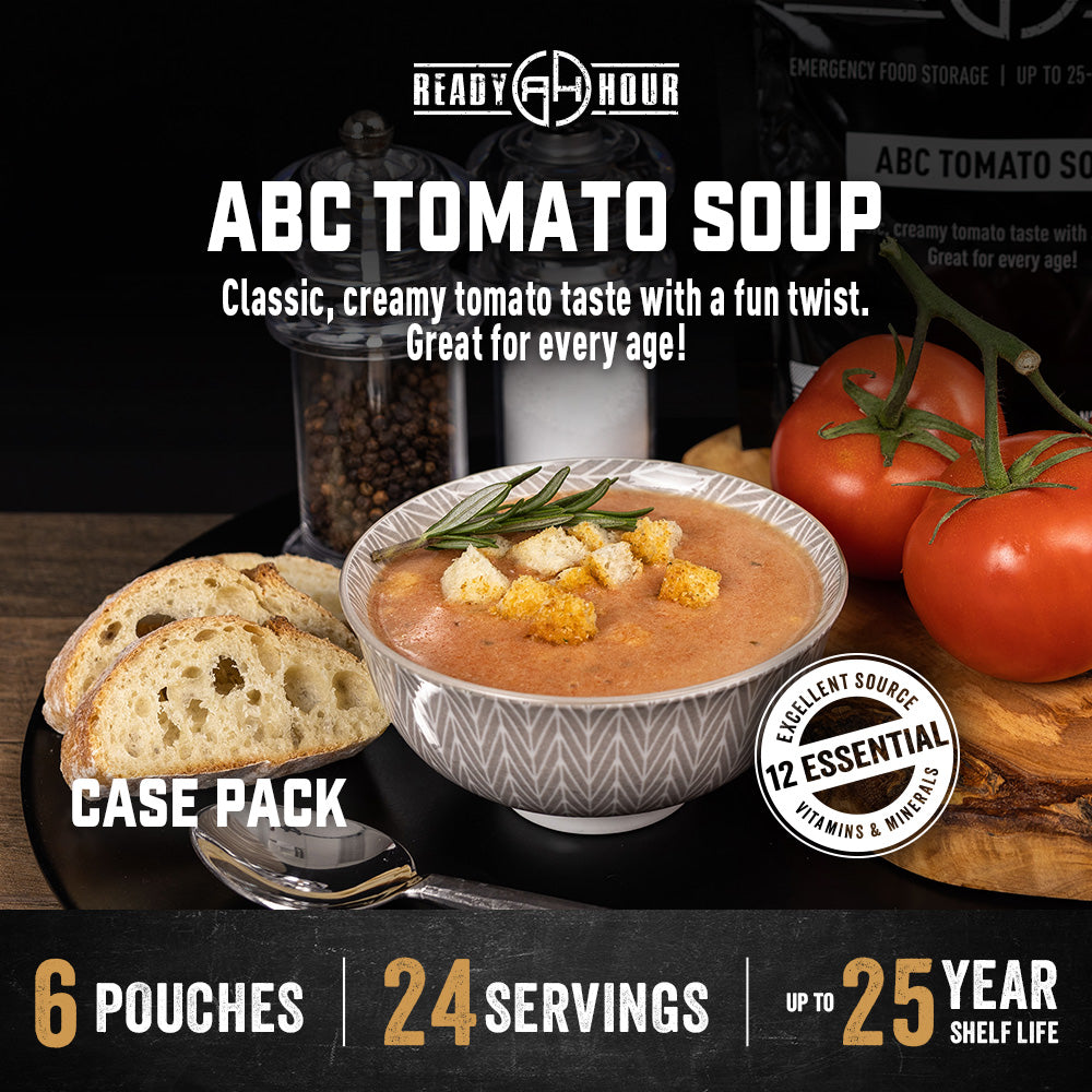 Tomato Soup in a bowl next to tomatoes and bread
