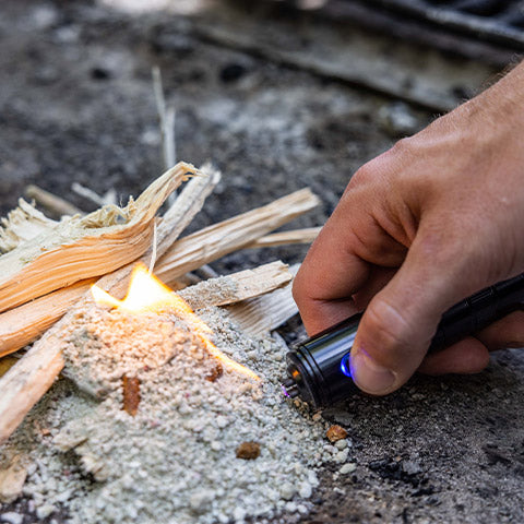 Hands starting a survival fire using flint and steel in the outdoors