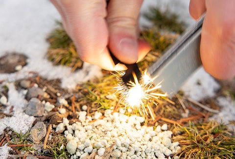 Someone lighting a fire with the Magnesium Fire Starter by InstaFire.r