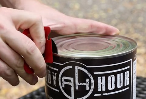 Person using a can opener to open a Ready Hour #10 can of emergency food.