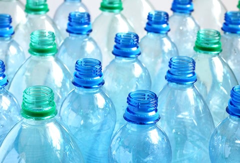 Plastic water bottles without blue and green lids.