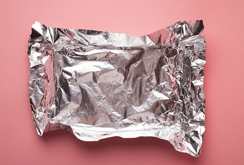 Crumpled tin foil on a pink background.