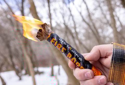 A lit InstaFire Fire Rope out in the snow.