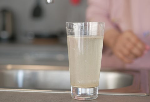 Contaminated water in a glass on the kitchen countertop.
