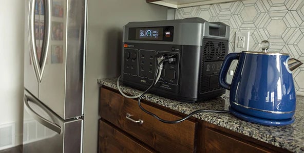 Shows a Grid Doctor battery being used in the kitchen.