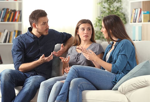 A family sitting together on the couch, talking about their emergency plan.