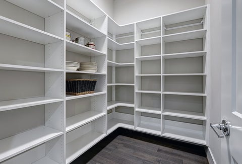 A large home pantry with white shelves, all mostly empty.