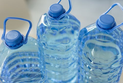 Three large, blue water storage containers.