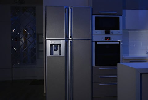 A closed refrigerator in a dark kitchen during a power outage.
