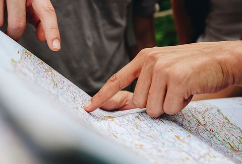 People pointing to a map, plotting their escape.