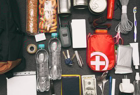 Emergency supplies laid out on a black surface.