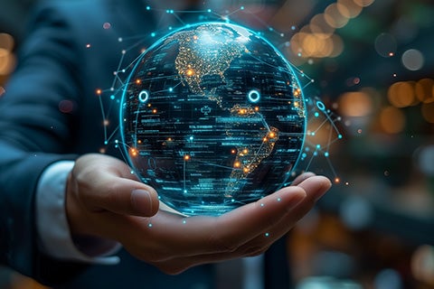 A human in a business suit, palm extended. A digital world is floating above the palm.