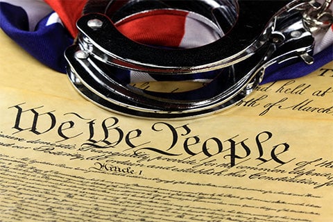 A set of handcuffs placed over the Declaration of Independence.