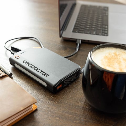 Grid Doctor 65W Power Bank on a desk charging a laptop