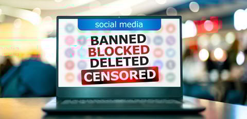a laptop with the words banned, blocked, delete, censored on it