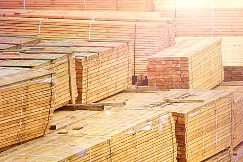 A bunch of stacks of two by four pieces of wood bound together.