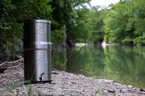 The Alexapure Pro Water Filtration System sitting next to a river.