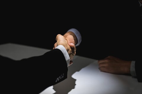 Businessmen shaking hands on a deal.